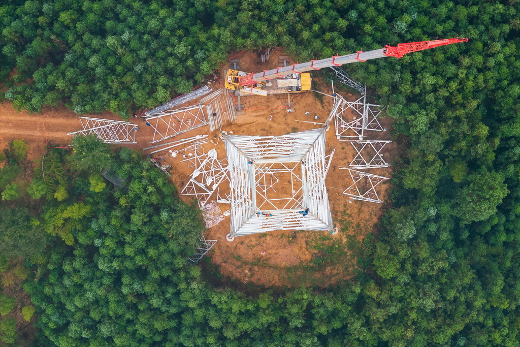 9月16日，在位于常德市桃源縣的“寧電入湘”工程沅江跨越施工現(xiàn)場，電力工人在進行組塔作業(yè)（無人機照片）。