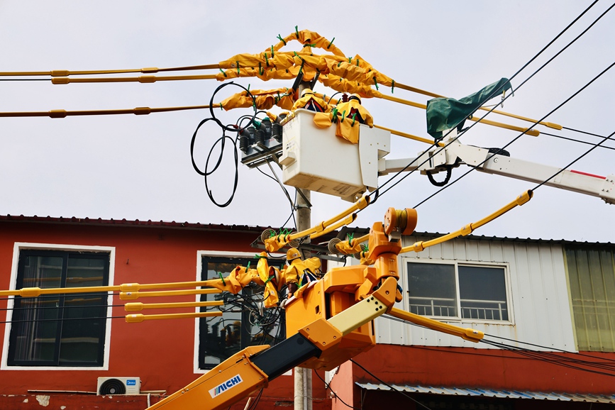 河南洛陽孟津供電公司帶電作業(yè)人員在10千伏麻水線開展帶電加裝柱上開關(guān)作業(yè)。劉偉韜 攝