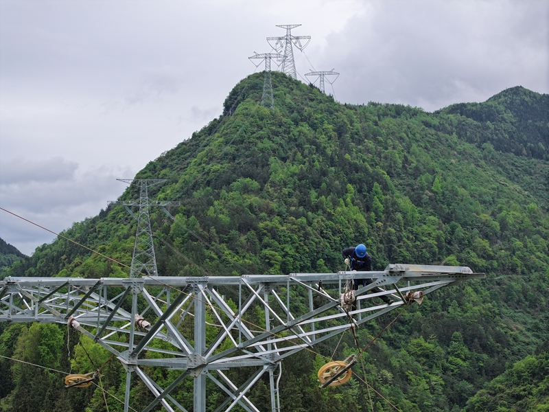2、在500千伏務(wù)川輸變電工程線路作業(yè)現(xiàn)場(chǎng)，施工人員正在牽引導(dǎo)線。 潘聰 攝.JPG
