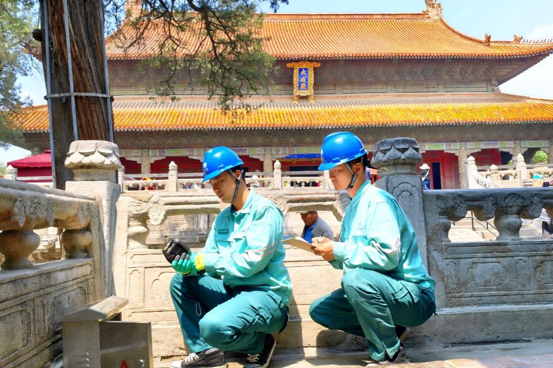 國網(wǎng)濟寧供電公司工作人員在“三孔”景區(qū)檢查杏壇配電設(shè)備