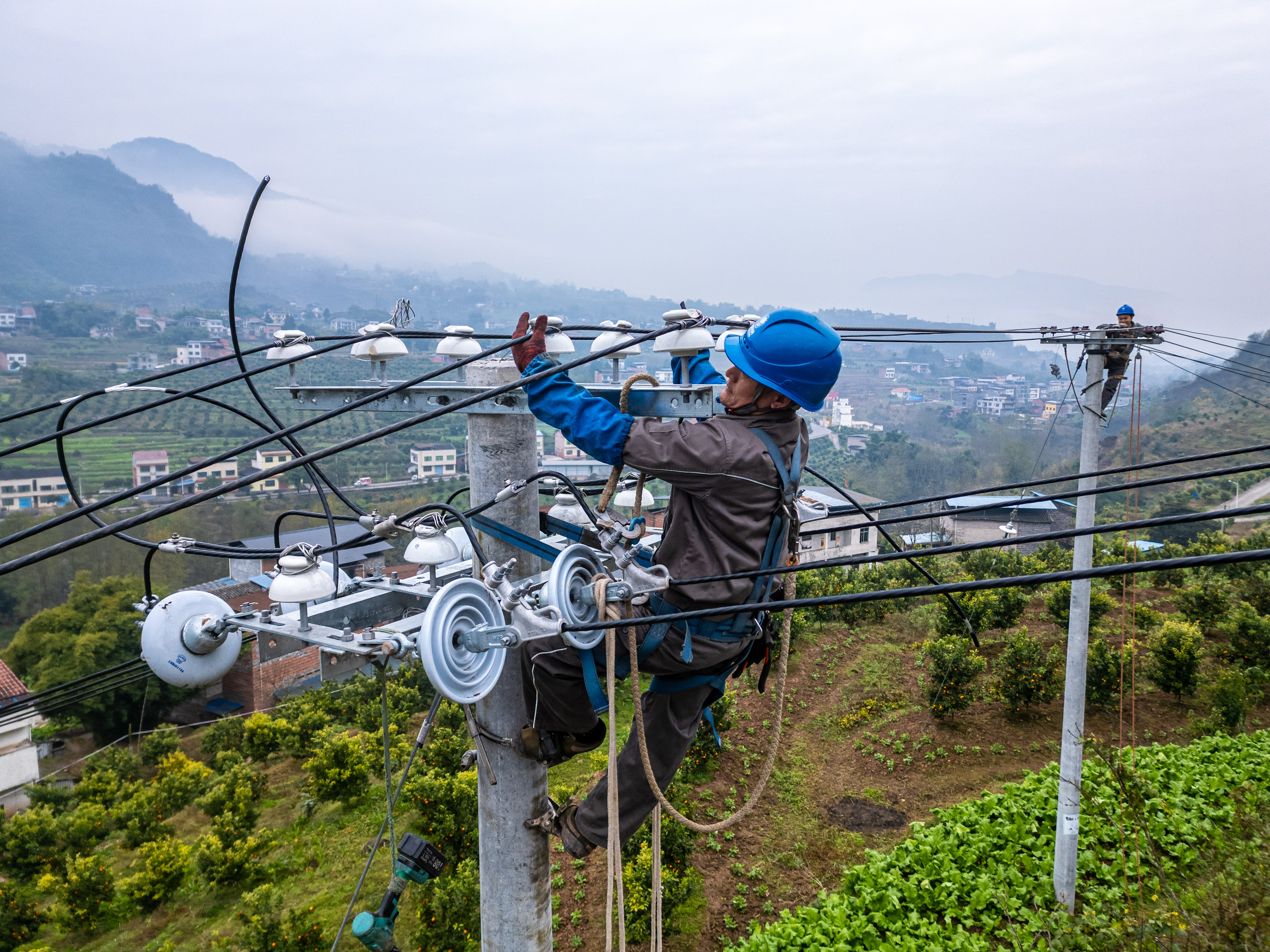 1月10日，重慶開州供電公司員工向祖春等在臨江鎮(zhèn)永東村，對10千伏明洪線開展低電壓治理。（李添鑫）   (5).jpg