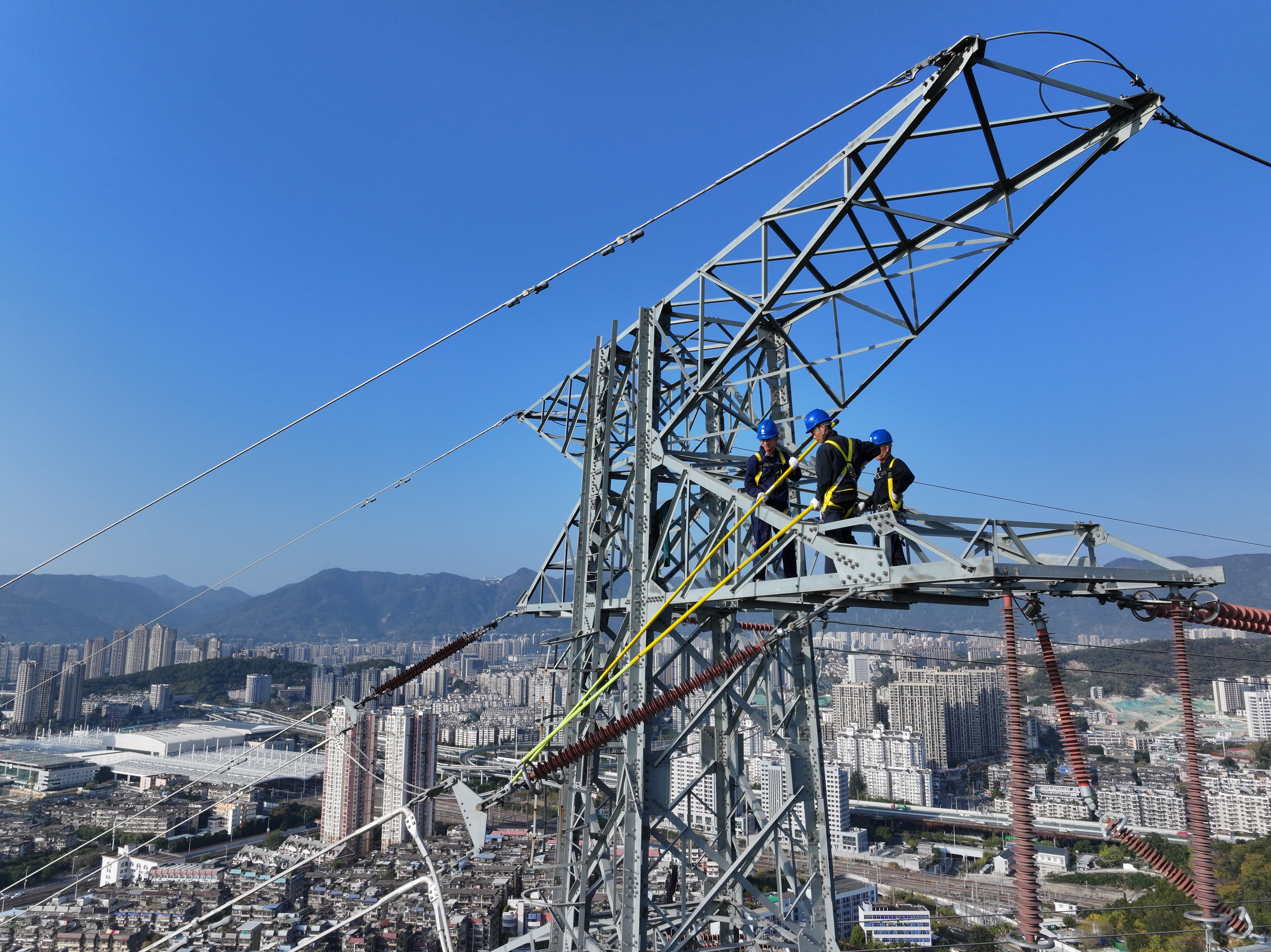 1月16日福建福州供電公司員工吳能錦、廖肇葵和陳端樞在福建省福州市晉安區(qū)金雞山220千伏榕公線37號塔對金具、絕緣子串等設備進行檢查維護。（陳德鈞）1.jpg
