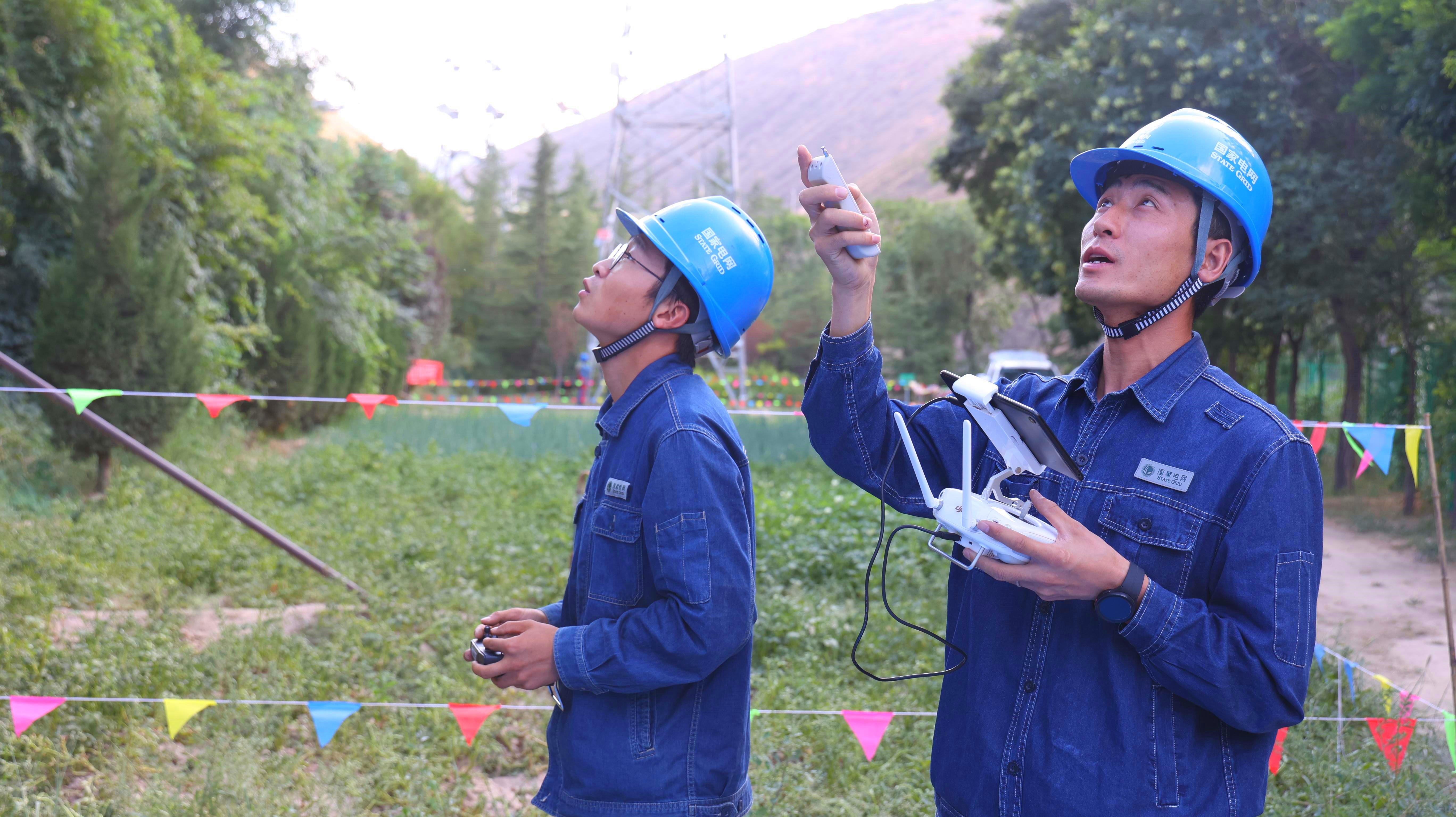 8月25日，國網(wǎng)蘭州供電公司工作人員在蘭州石板山輸電線路技能培訓(xùn)基地使用“‘歐姆雙翼式’無人機接觸式驗電器及接地裝置”完成高空輸電線路的接觸式驗電及接地。李小東攝 (1).jpg